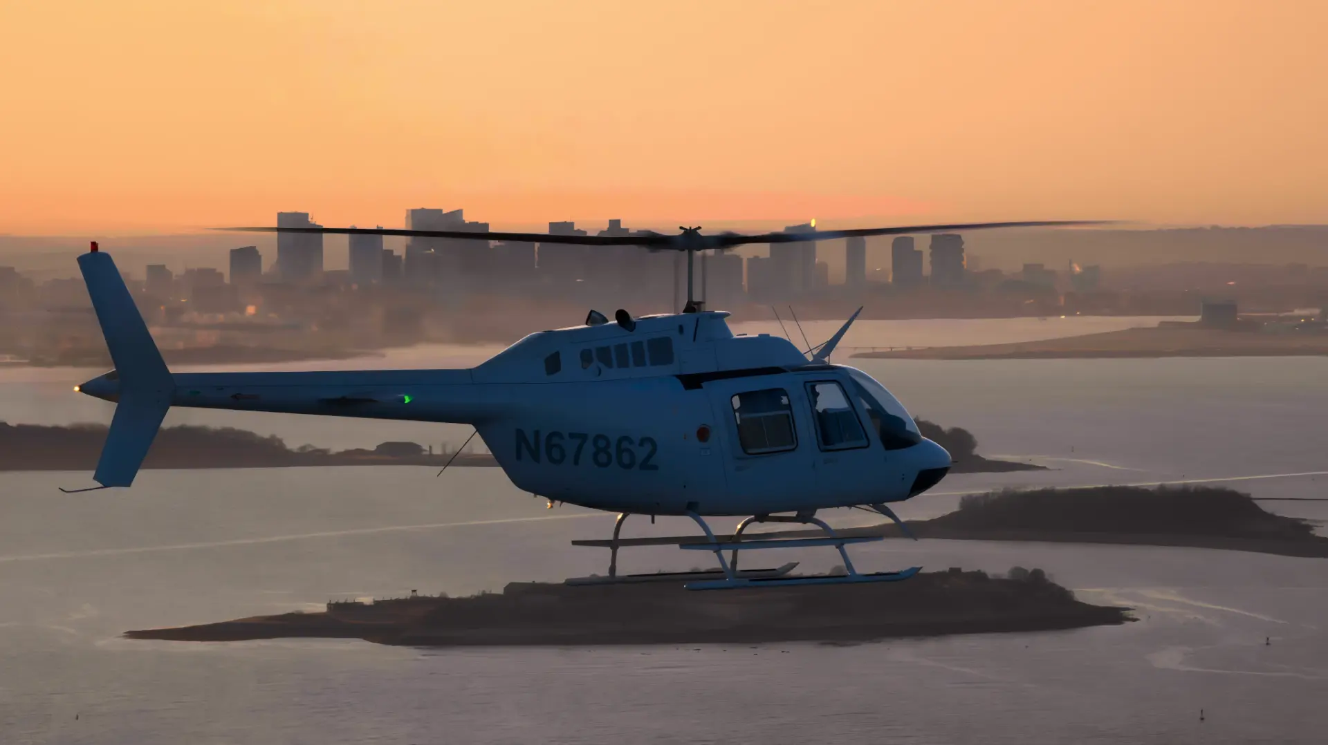 Bell 206 helicopter over Boston Harbor at sunset